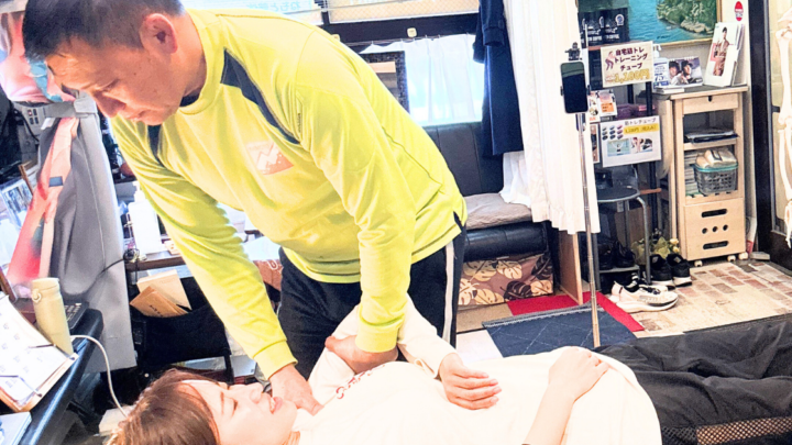 女性が肩を押さえられている