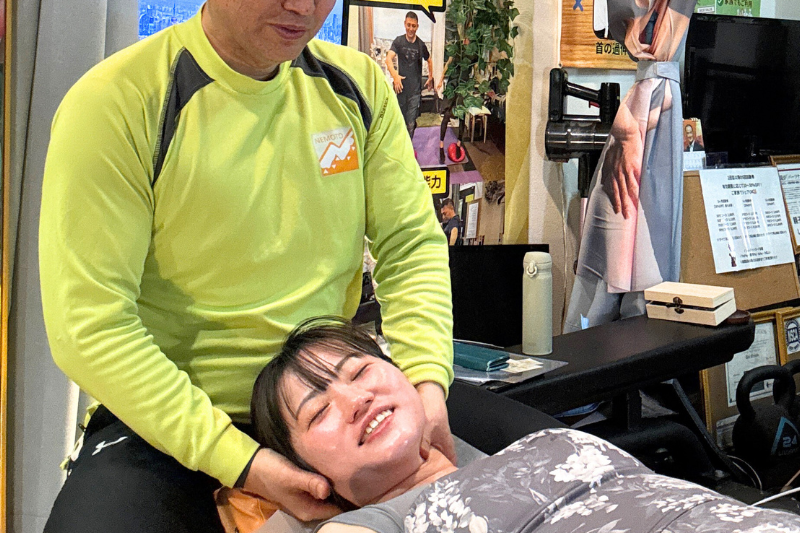 女性が笑顔で整体を受けている